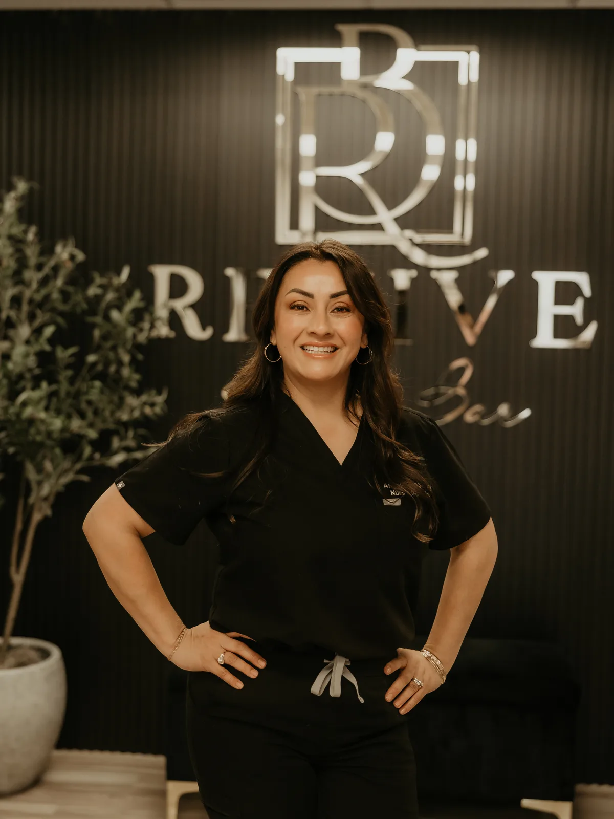 Angelica Alcaraz, BSN, RN, junto al letrero de Revive Beauty Bar en Salinas