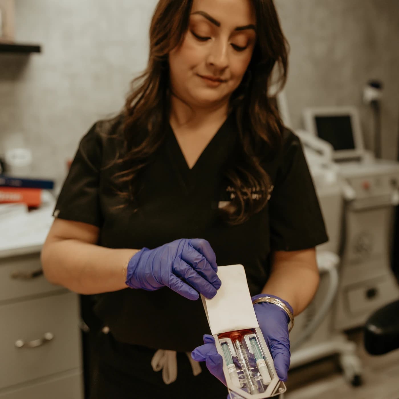 Angelica Alcaraz, BSN, RN, opening a dermal filler carton at Revive Beauty Bar in Salinas, CA
