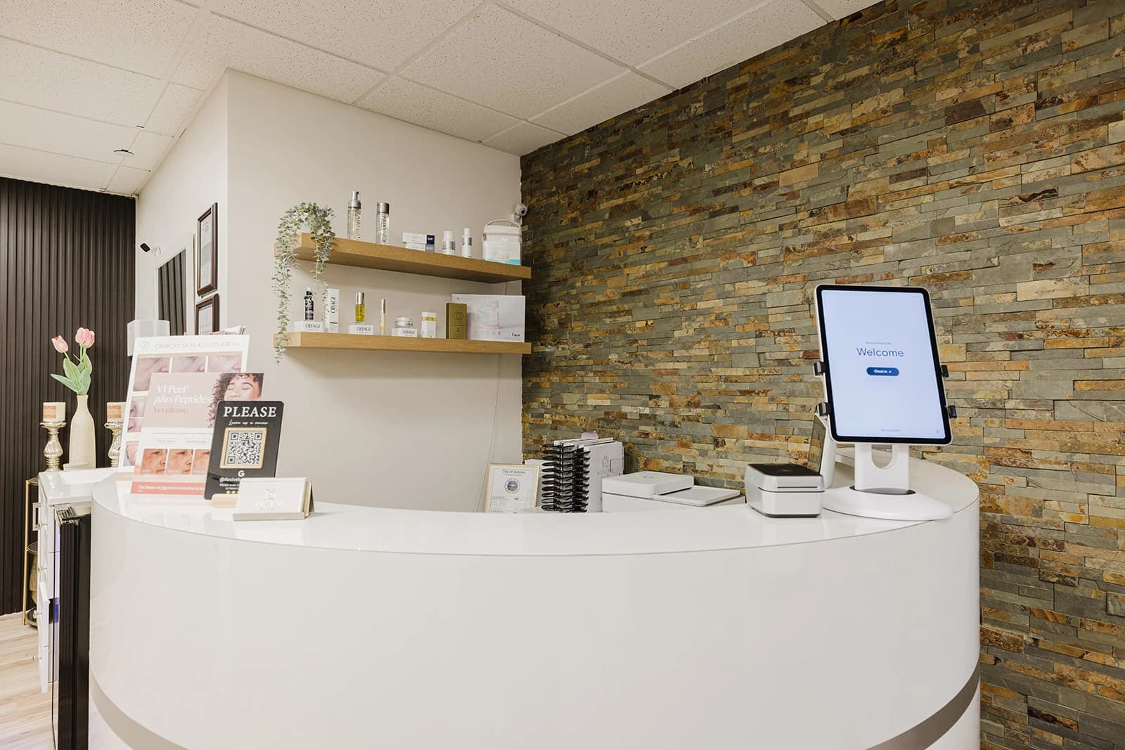 El escritorio de recepción y los estantes de skincare en Revive Beauty Bar en Salinas