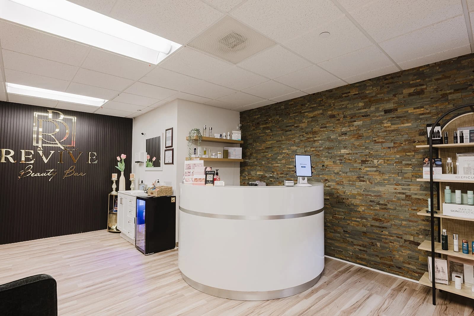 El lobby de Revive Beauty Bar en Salinas, con el letrero iluminado de la marca sobre la recepción