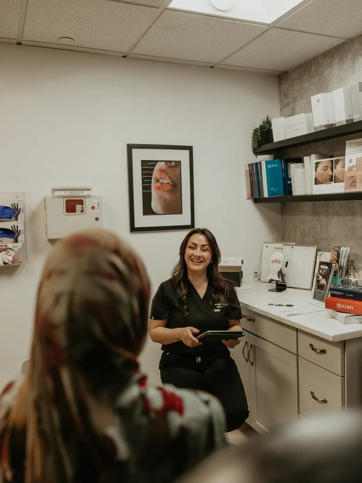Angelica Alcaraz, BSN, RN, repasando el plan de tratamiento y los precios del Aerolase con una clienta en Revive Beauty Bar en Salinas, California
